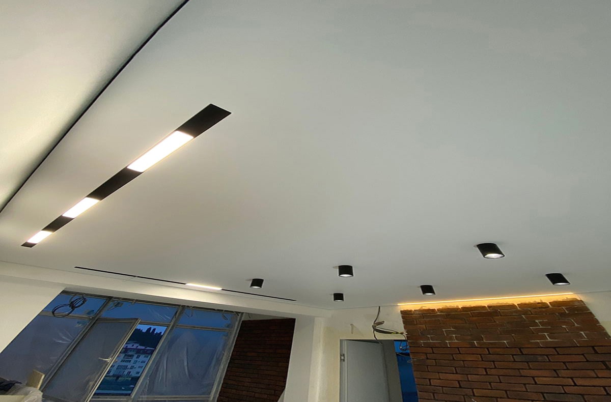 Теневой натяжной потолок с трековыми светильниками и нишей 